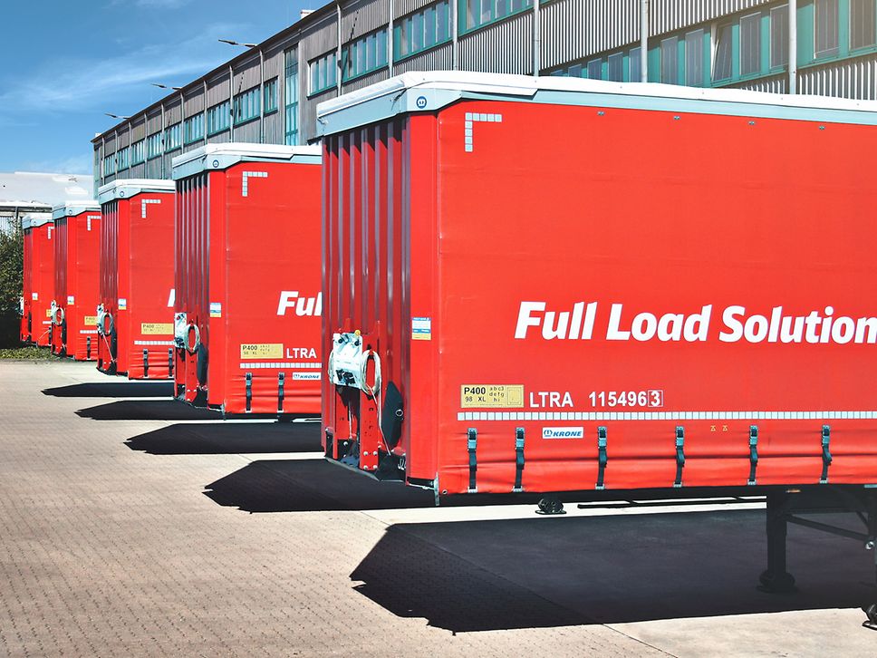 Fünf rote Trailer von DB Cargo FLS stehen an Laderampen.