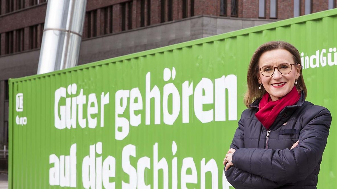 Dr. Sigrid Nikutta steht vor einem grünen Container mit der Aufschrift Güter gehören auf die Schiene.