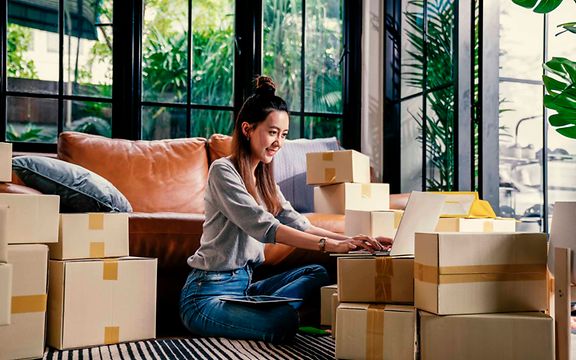 A woman sits in the middle of packages.