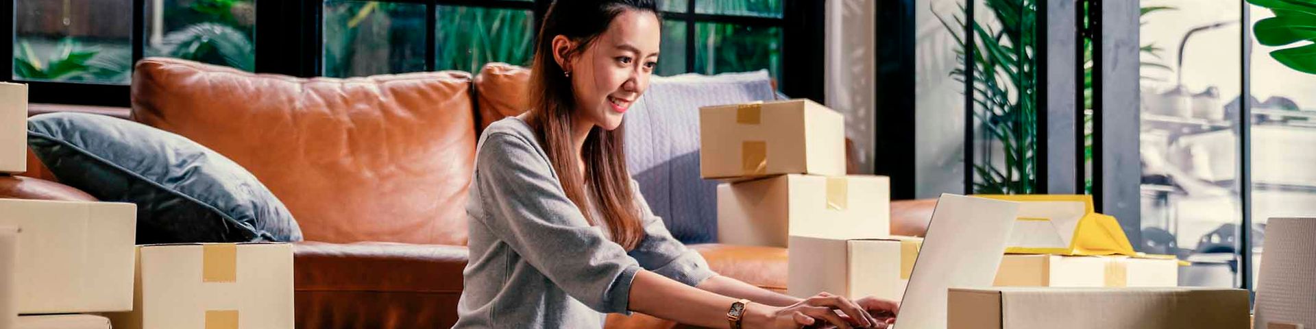 A woman sits in the middle of packages.