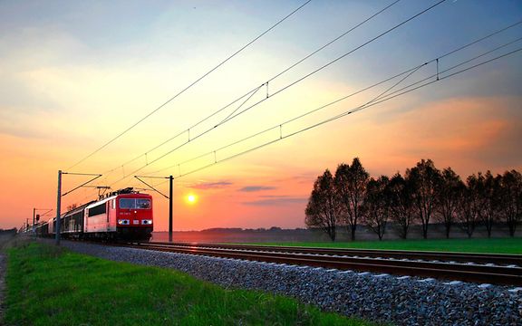 Ein Güterzug fährt im Sonnenaufgang