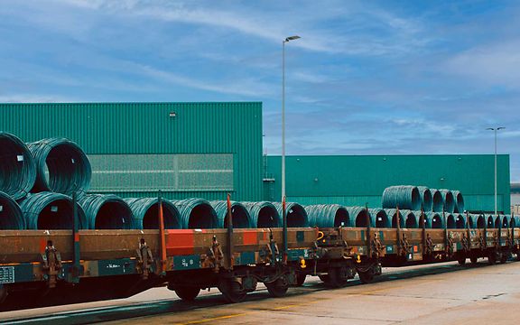 Stahlrollen liegen zum Transport auf einem Güterwagen bereit.