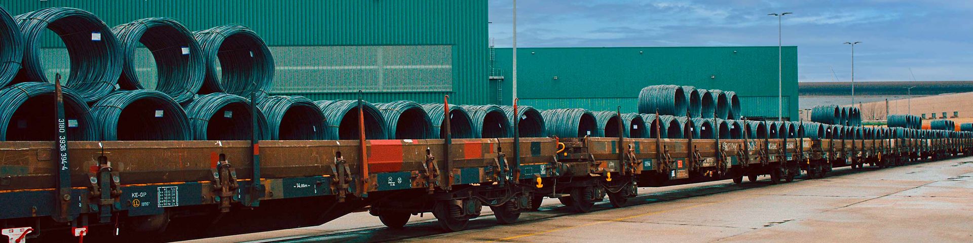 Stahlrollen liegen zum Transport auf einem Güterwagen bereit.