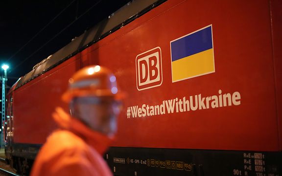 Auf einem Güterzug ist das DB Cargo-Logo, die ukrainische Flagge und der Hashtag #WestandwithUkraine zu sehen.