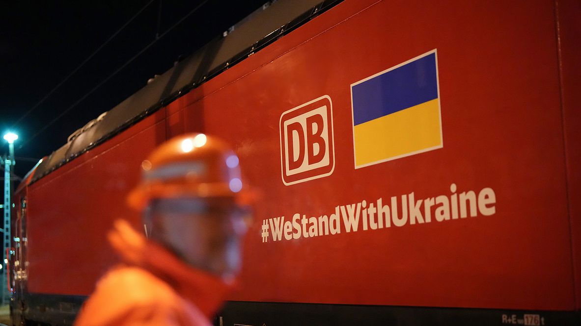 Auf einem Güterzug ist das DB Cargo-Logo, die ukrainische Flagge und der Hashtag #WestandwithUkraine zu sehen.