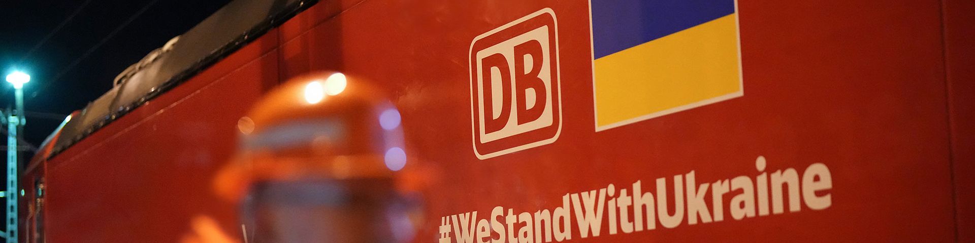 Auf einem Güterzug ist das DB Cargo-Logo, die ukrainische Flagge und der Hashtag #WestandwithUkraine zu sehen.