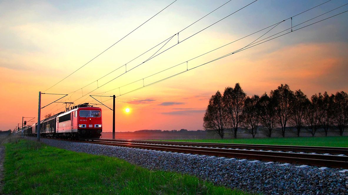 A goods train travelling at sunrise
