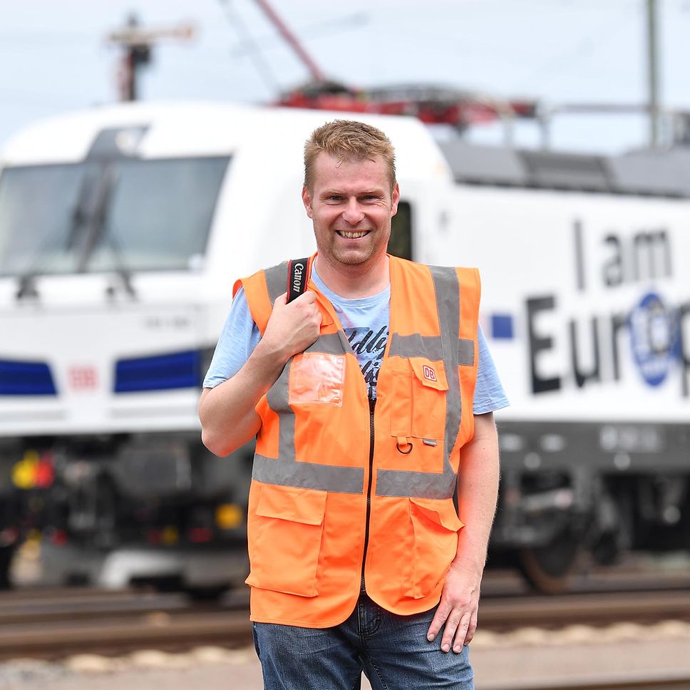 A man in front of a locomotive.