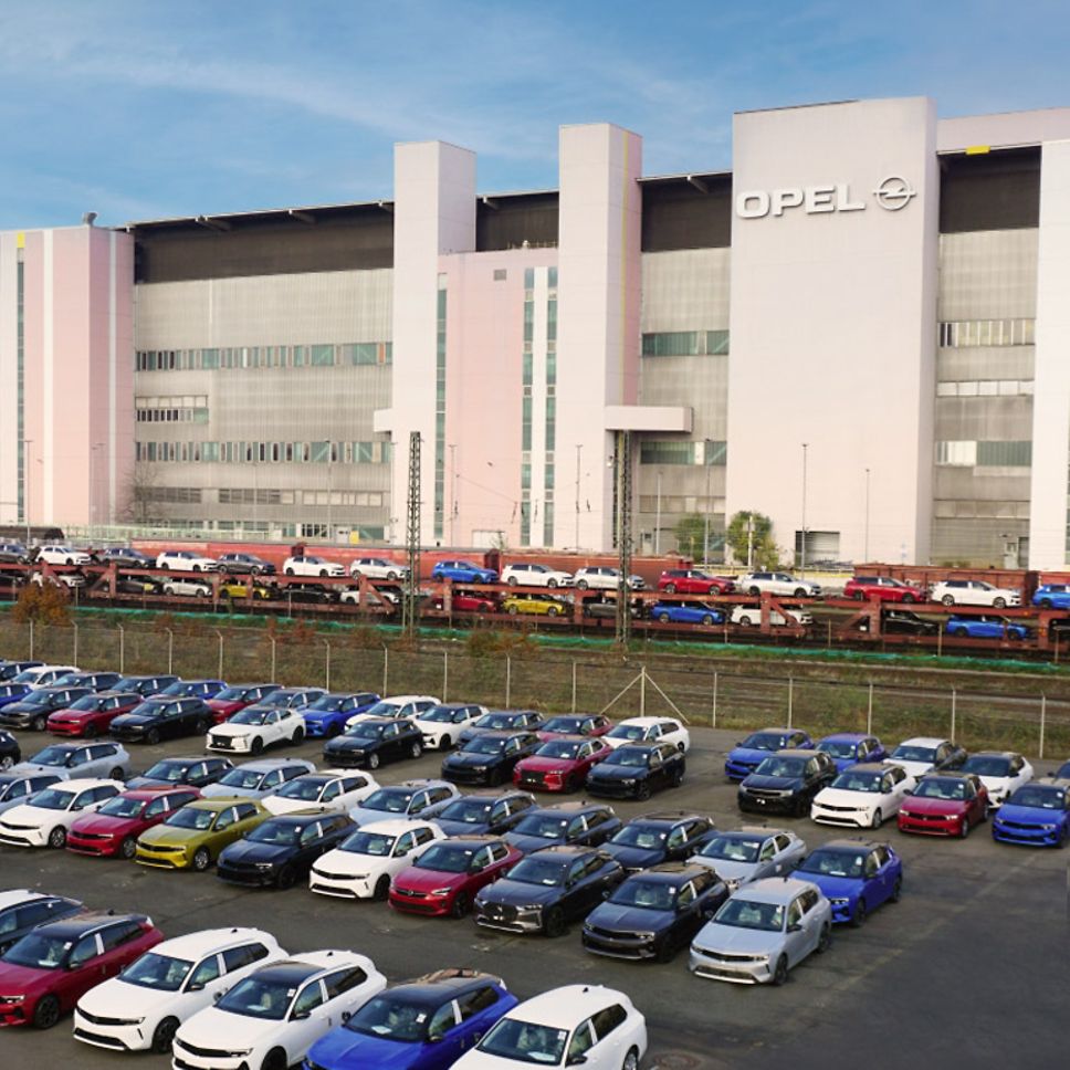 The Opel plant with vehicles in front of it.