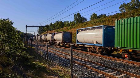 A goods train with tank containers passes by.