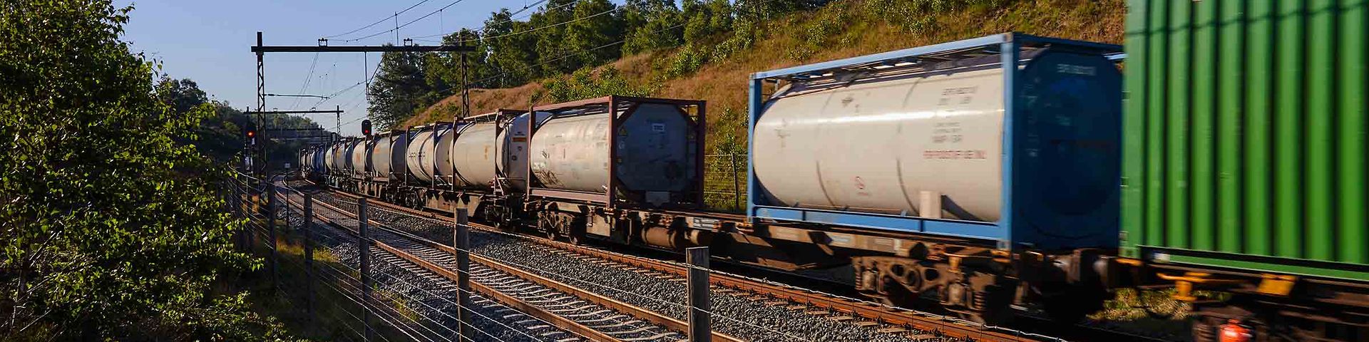 A goods train with tank containers passes by.