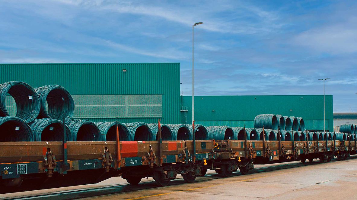 Stahlrollen liegen zum Transport auf einem Güterwagen bereit.