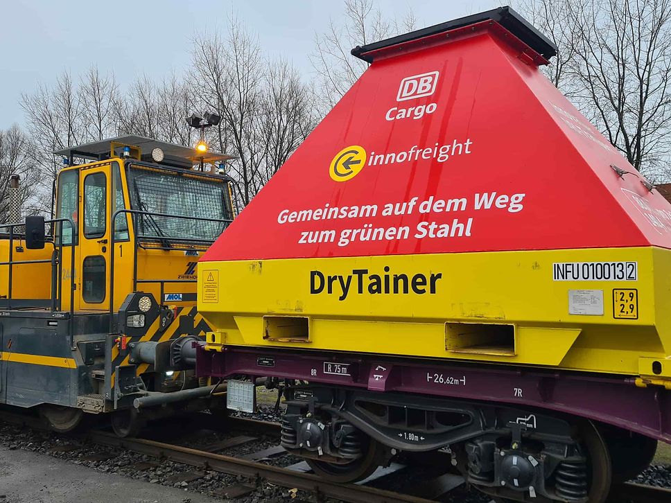 A red and yellow DryTainer from Innofreight mounted on a DB Cargo freight wagon.