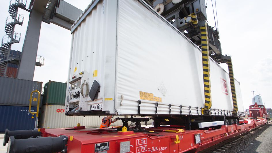Sattelauflieger wird auf Güterwaggon verladen