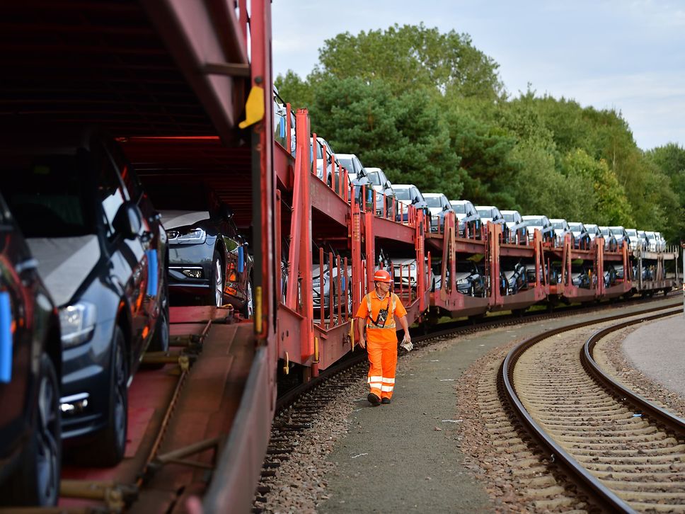 DB Cargo Mitarbeiter geht an einem Automobilzug entlang.