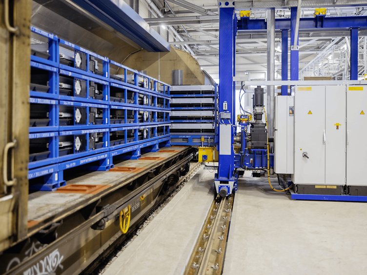 Automatic loading facility at an automotive plant loads batteries into a sliding-wall wagon