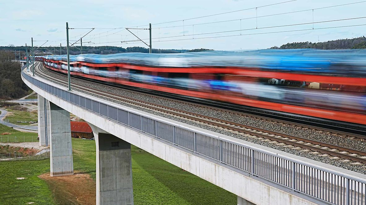 Autotransportzug fährt über Brücke