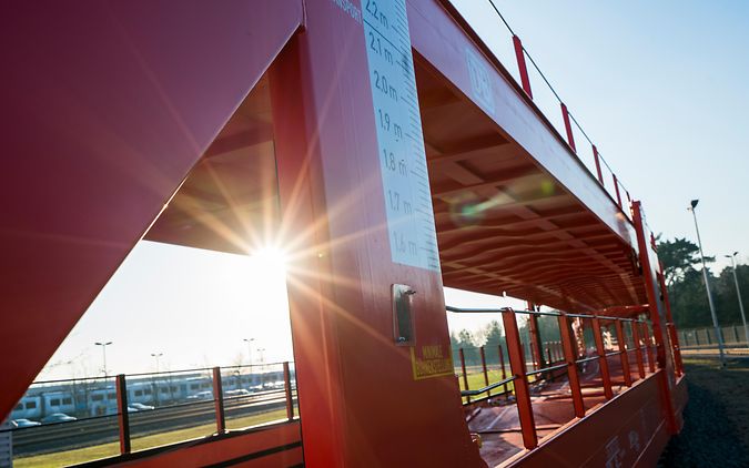 Offener Autotransportwagen mit zwei Ladeebenen und Sonnenstrahl 