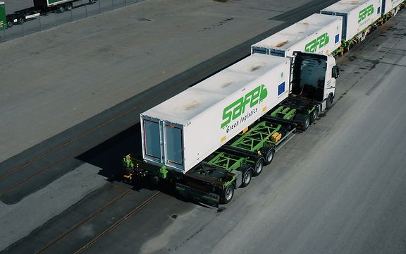 A bird's eye view of the autonomous transfer of a container from a truck to a freight wagon