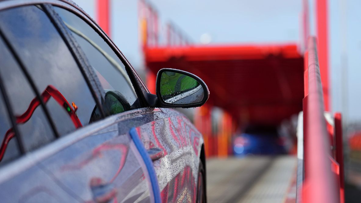 Fahrzeuglogistik auf der Schiene: Ein Pkw fährt auf einen Autotransport-Güterwagen