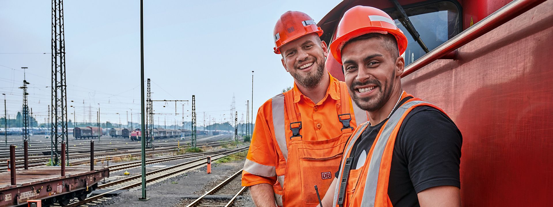 Zwei Männer in Schutzkleidung auf einer Lok