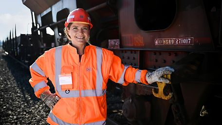 Frau im orangen Overall als Lokrangierführerin
