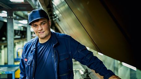 Junger Mann im Blaumann in Werkstatt