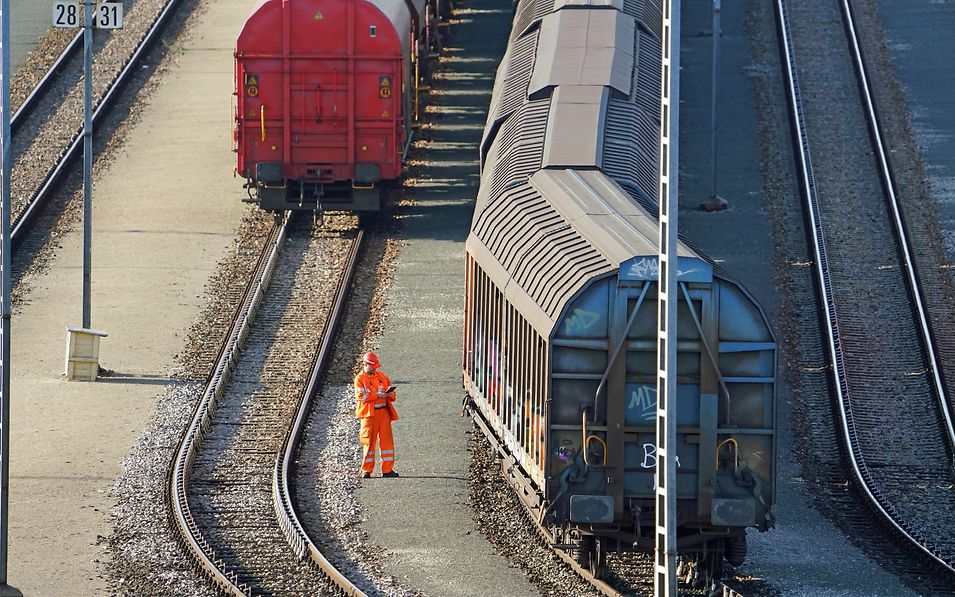 Wagenmeister von DB Cargo bei der Prüfung eines Güterzugs