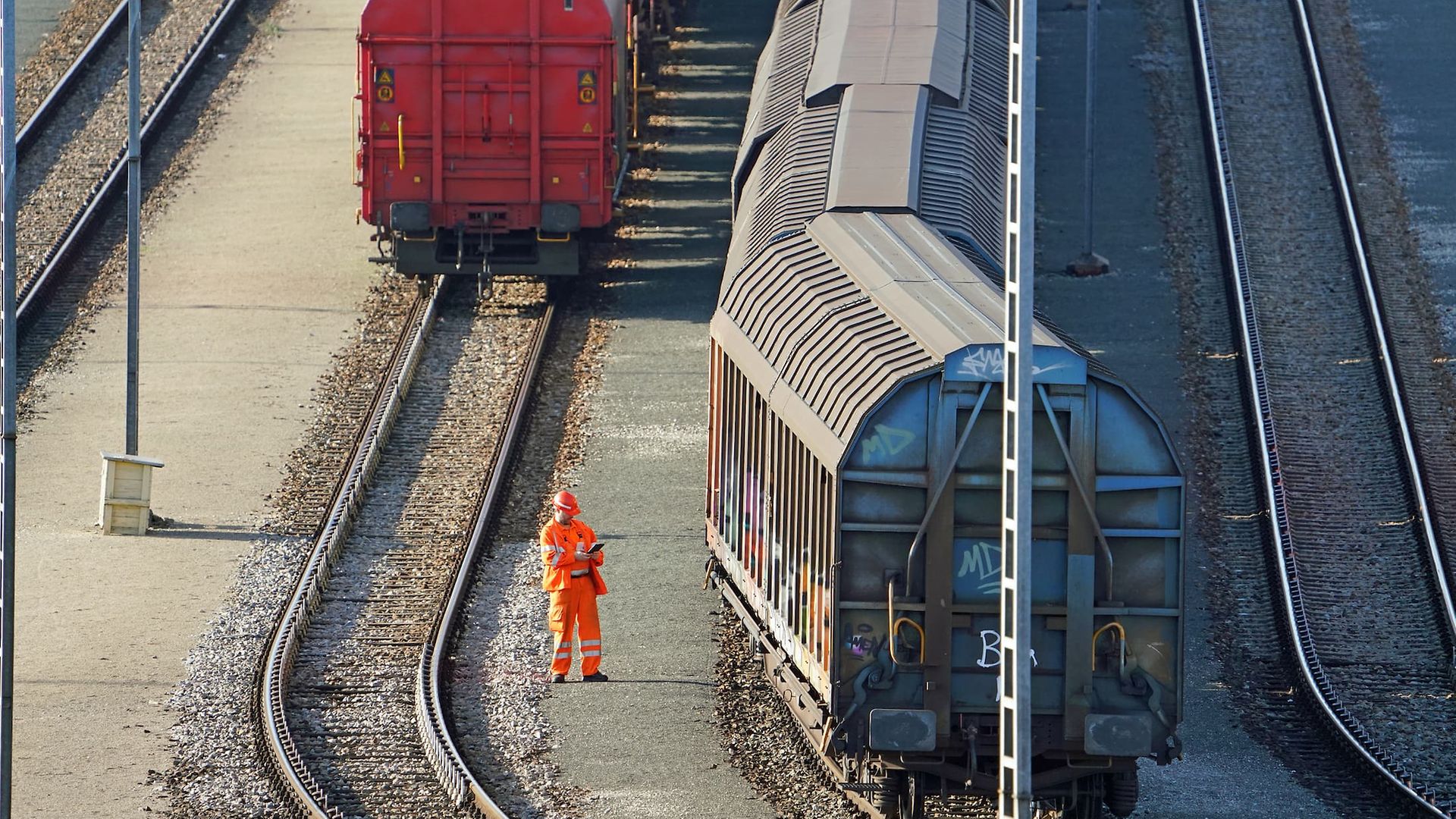 Wagenmeister von DB Cargo bei der Prüfung eines Güterzugs