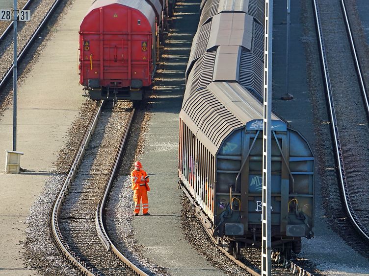 Wagenmeister von DB Cargo bei der Prüfung eines Güterzugs