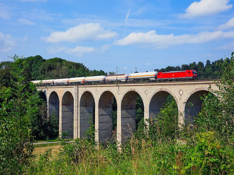 A freight train with pressurised gas tank wagons crosses a bridge