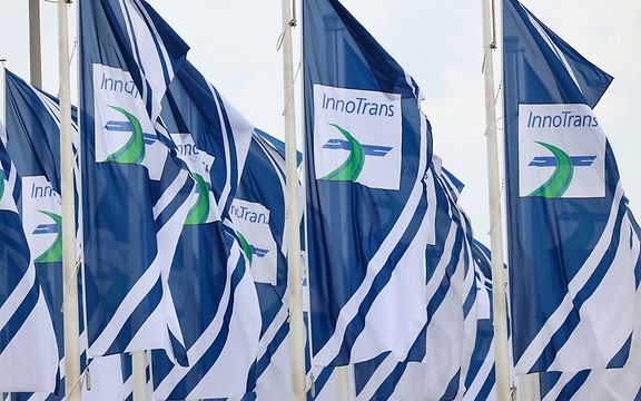 Several flags fluttering in the wind with the words “InnoTrans” on them