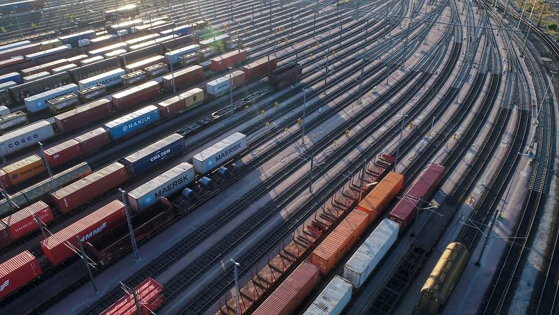 Großer Güterbahnhof mit verschiedenfarbigen Waggons im Abendlicht