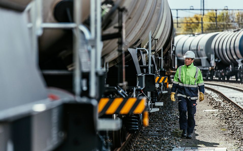 Arbeiter läuft an einem stehenden Wagen entlang