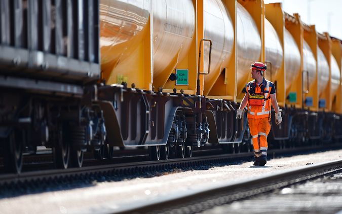 DB Cargo Mitarbeiter läuft Kesselwagenzug entlang