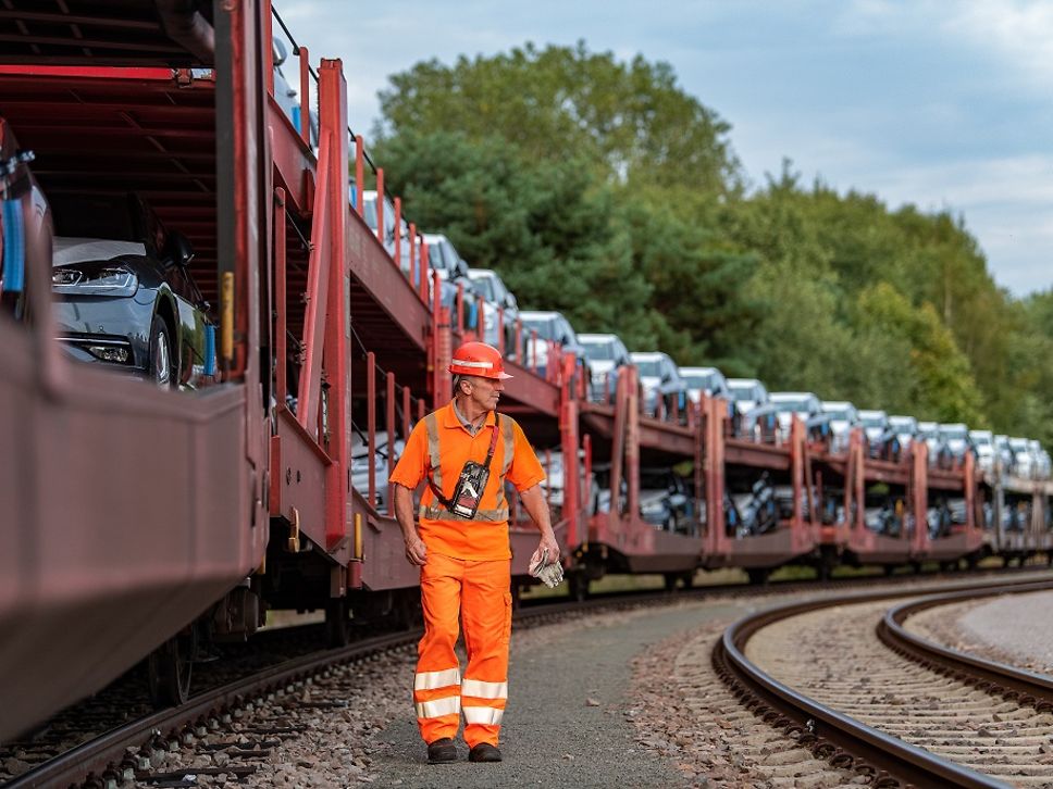 Mann läuft neben Autozug