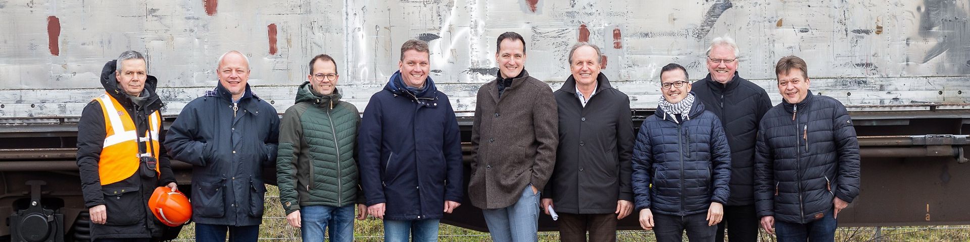 Das Team von DB Cargo Logistics und Mitarbeiter von Binderholz und Bürgermeister Schwarz vor einem beladenen Waggon.