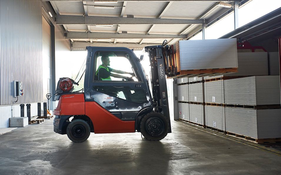 Forklift truck loads steel car on wagon