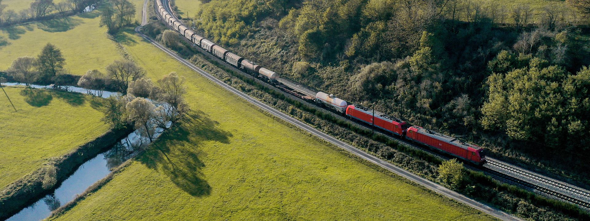 Freight train travelling through green landscape