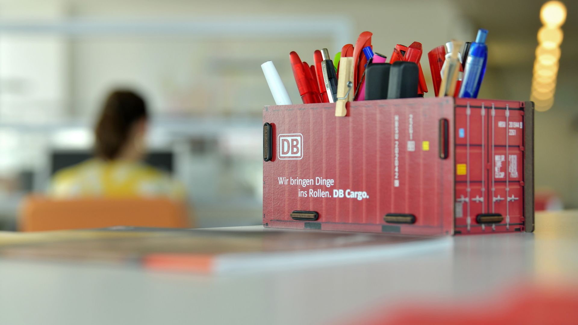 Callcenter-Agent, in front is a DB Cargo rail freight waggon as pen box