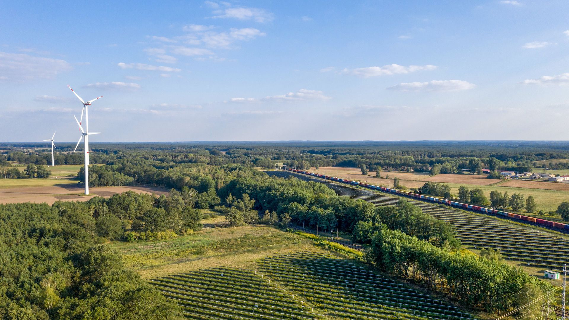 Ein Güterzug in einer Landschaft mit Windkraftanlagen