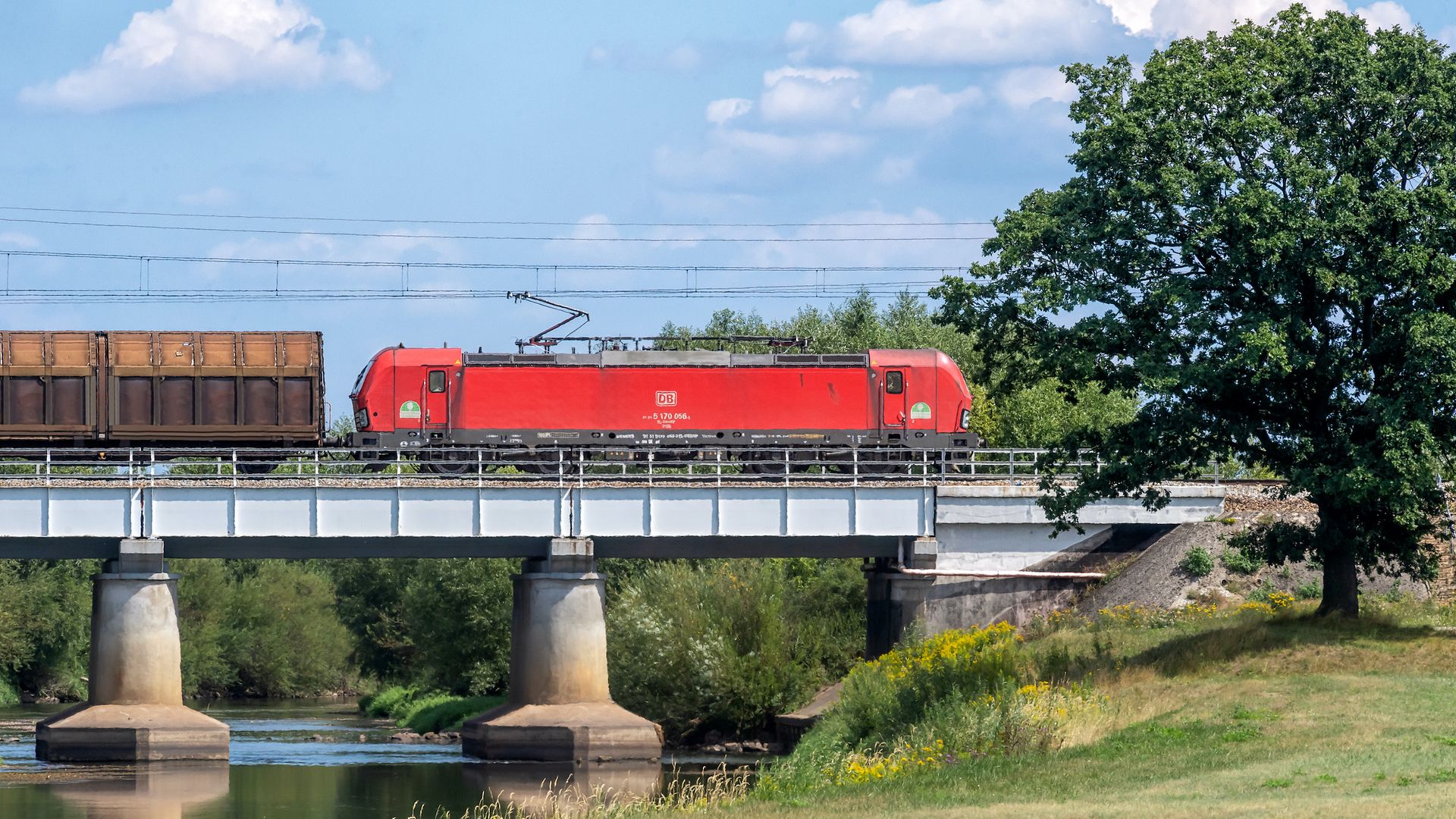 Güterzug auf einer Brücke über einen Fluss