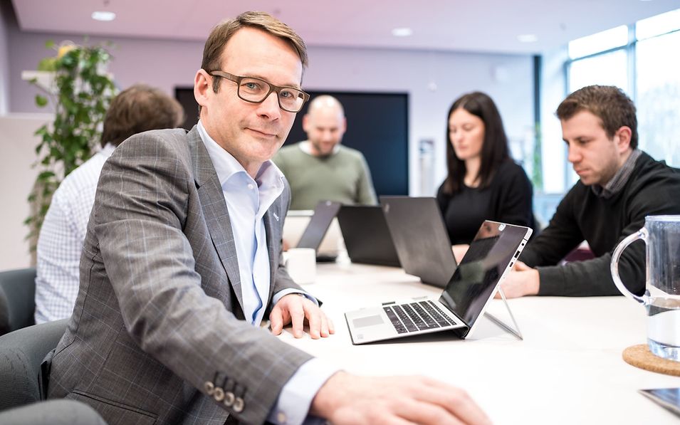 A group of employees with notebooks in a conference room.