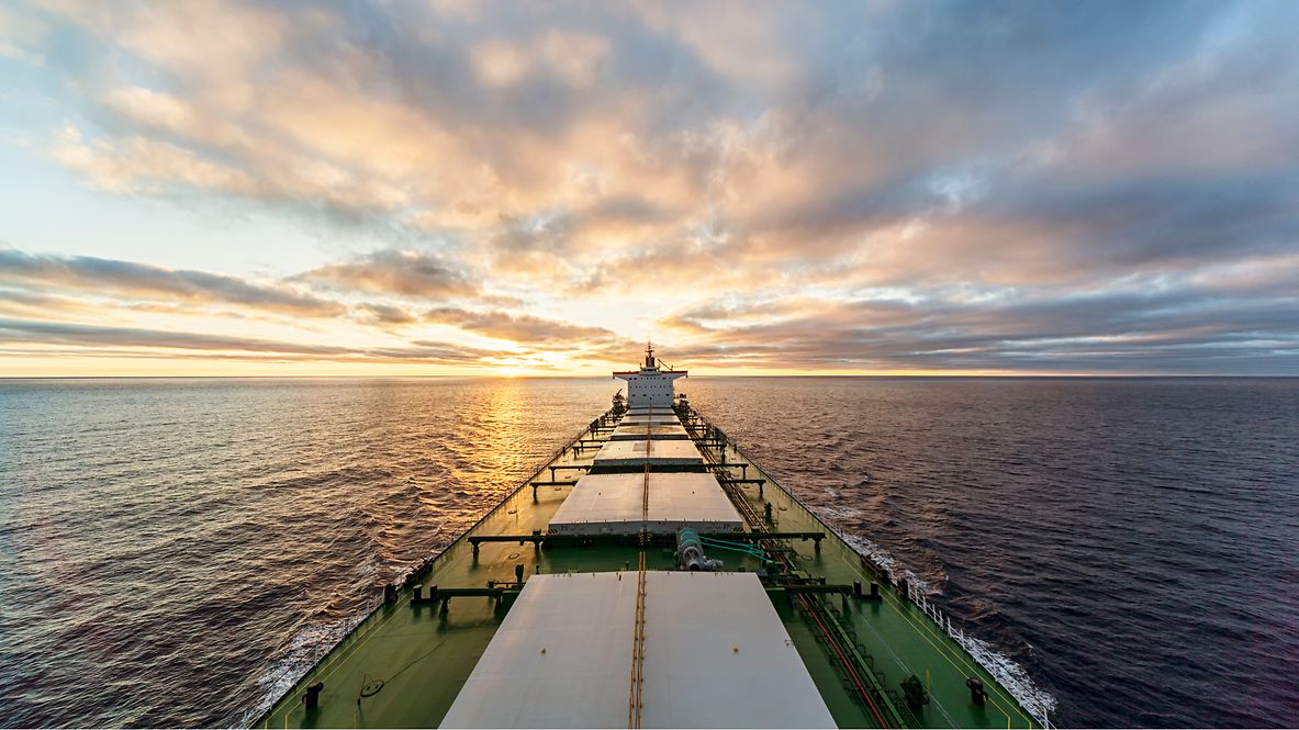 Seefrachter auf hoher See vor Sonnenaufgang