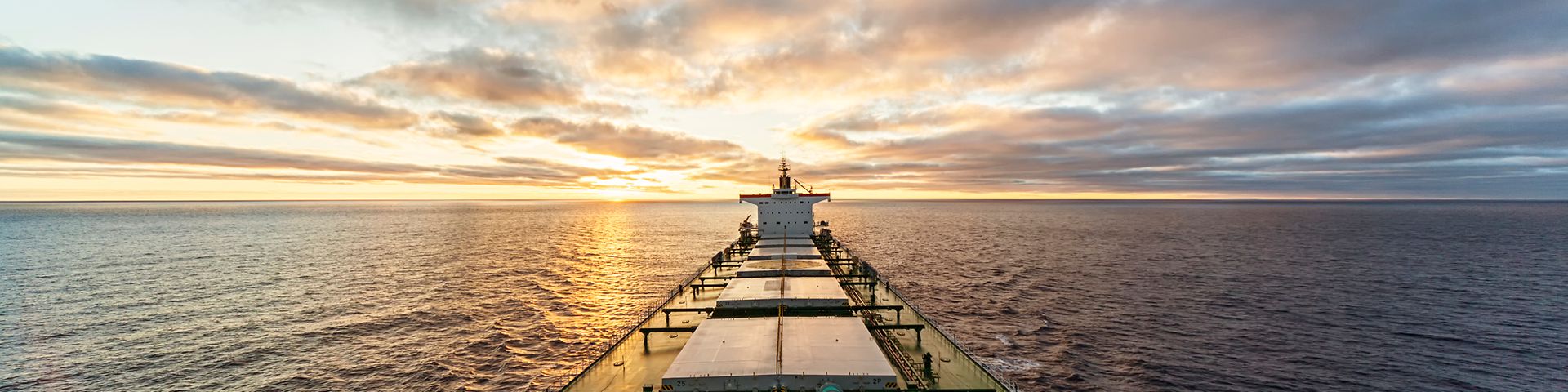 Seefrachter auf hoher See vor Sonnenaufgang