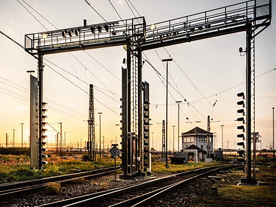 Zwei Kamerabrücken in der Morgendämmerung auf einem Güterbahnhof. 